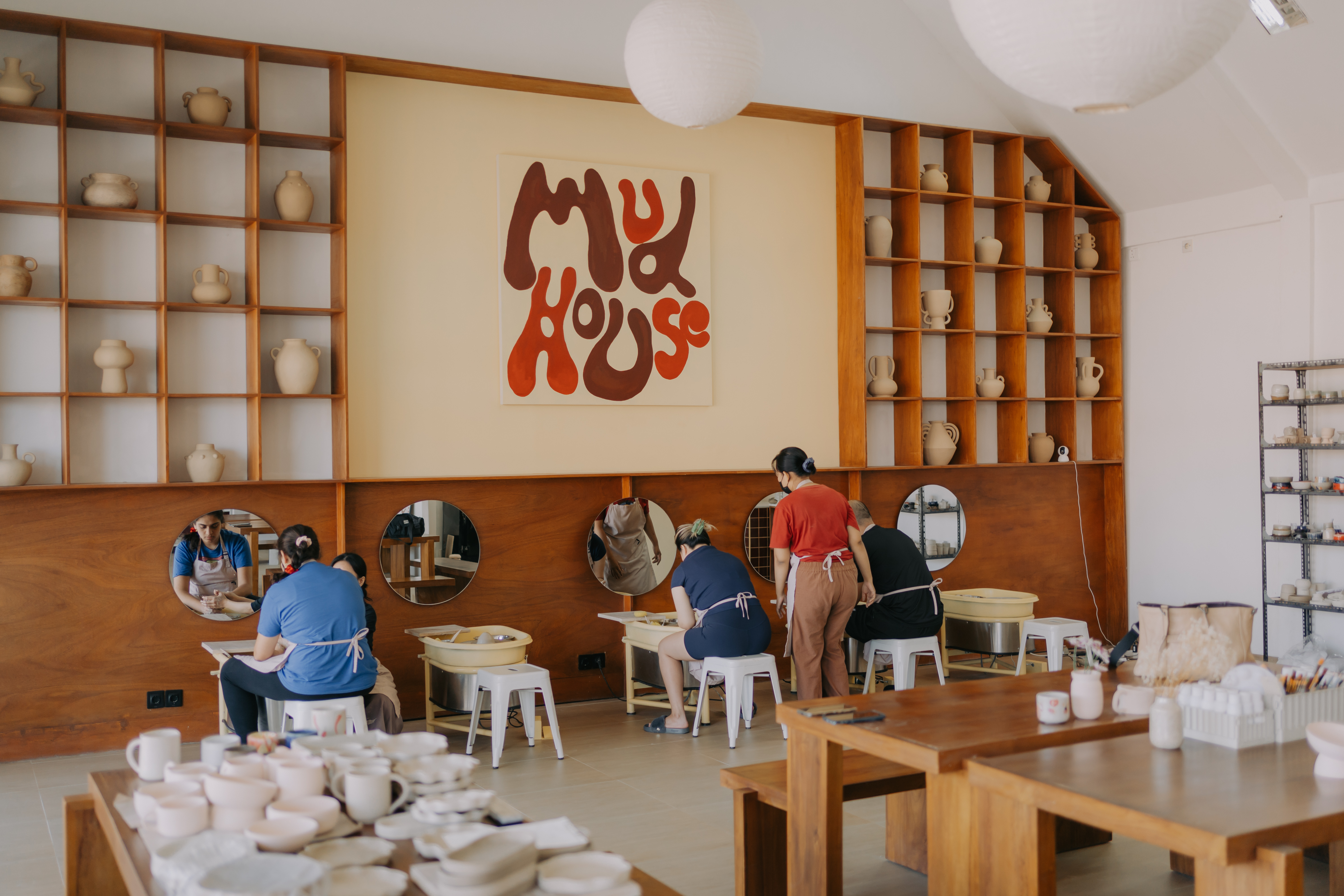 Mud House pottery studio with guests creating at the wheel