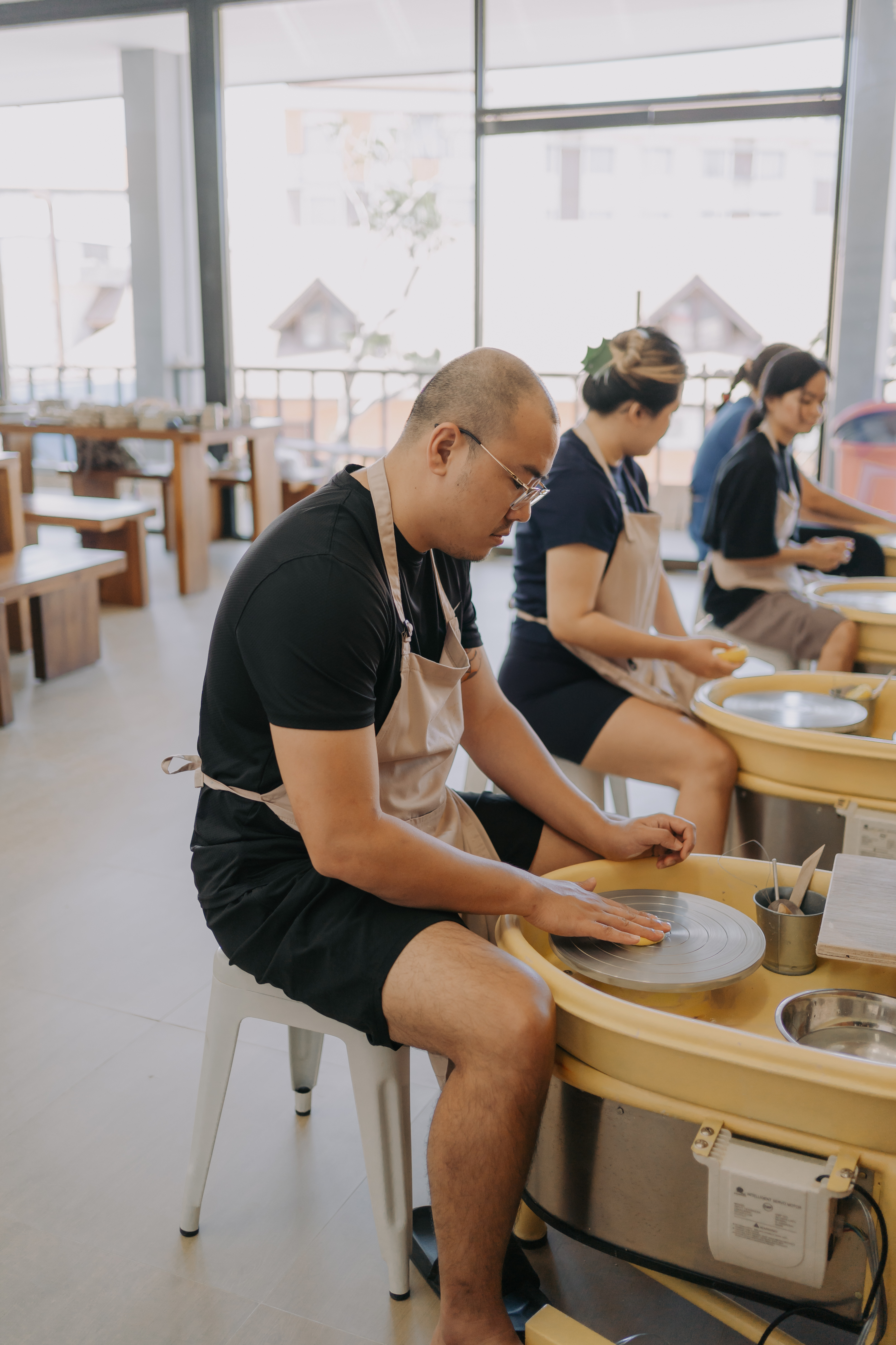 Guest learning wheel throwing at Mud House